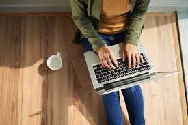 Ноутбук на деревянном столе в интерьере офиса с электроникой и компьютером.